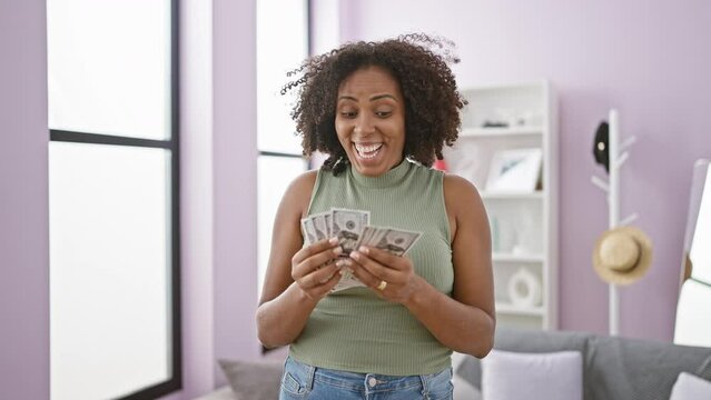 Happy woman holding money in modern living room