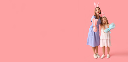 Happy mother and her little daughter with Easter gifts on pink background with space for text