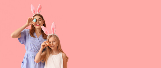 Happy mother and her little daughter with Easter eggs on pink background with space for text