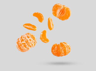 Flying fresh tangerines on grey background