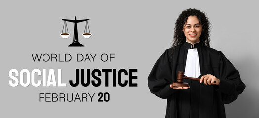 Beautiful young happy African-American female judge with gavel on grey background