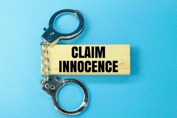 iron and wooden handcuffs with the words claim innocence. the concept of false accusations or...
