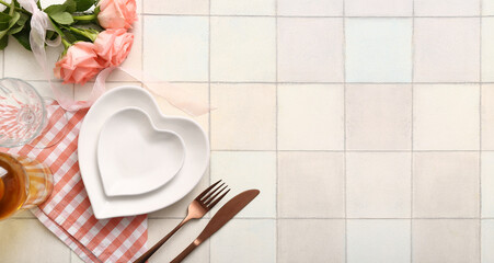 Beautiful table setting for Valentine's Day dinner on light tile background with space for text