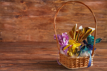 Fototapeta na wymiar Basket with chocolate Easter eggs on wooden table