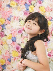 Obraz na płótnie Canvas お花に包まれてドレスを着た女の子の笑顔　