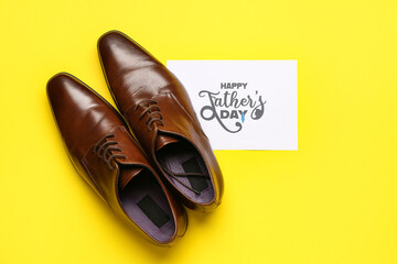 Stylish male shoes and card with text HAPPY FATHER'S DAY on yellow background