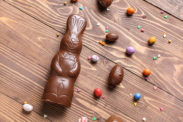 Chocolate Easter bunny with eggs and sprinkles on wooden background