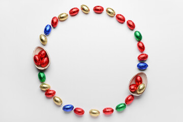 Frame made of chocolate Easter eggs in foil on white background