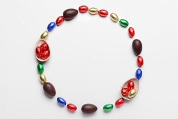 Frame made of chocolate Easter eggs on white background