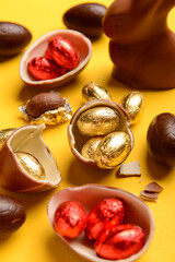 Chocolate Easter eggs and bunny on yellow background