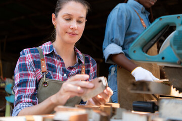Portrait of female carpenter working in her workshop at countertop