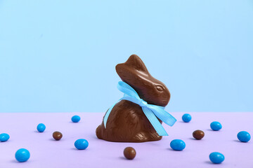 Chocolate Easter bunny and candies on colorful background