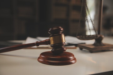 image of judge's hammer, scales lady of justice, law book, laptop computer and contract documents with pen concept of law and justice.