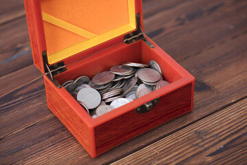 Dollar coins in a red wooden box