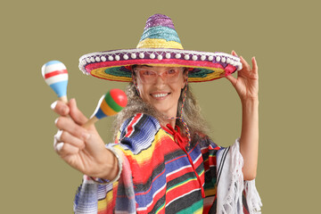 Mature woman in sombrero hat with maracas on color background. Mexico's Day of the Dead (El Dia de...