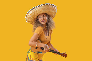 Mature woman in sombrero hat playing guitar on yellow background. Mexico's Day of the Dead (El Dia...
