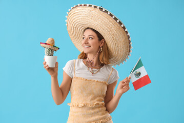 Pretty young woman in sombrero with cactus and Mexican flag on blue background