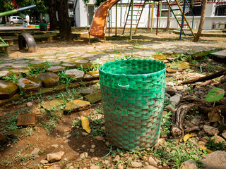 Trash cans made from recyclable plastic are located in the playground