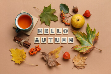 Composition with text HELLO AUTUMN, cup of tea and natural forest decor on color background
