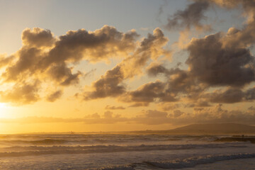 Obraz premium Tender ocean sunset. Sunset over the water with birds flying against sunlight on the North Atlantic ocean