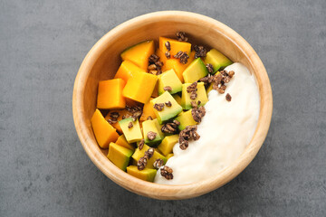 A bowl of yogurt granola with mango and avocado, healthy breakfast
