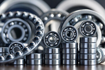 Metal silver radial ball bearings close-up for mechanical engineering, machine tools and equipment, neatly arranged with a ladder up and in a row similar to a diagram against - obrazy, fototapety, plakaty