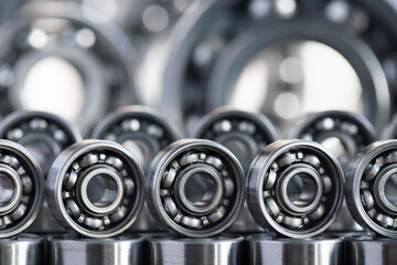 Radial ball bearings made of metal close-up in silver color for mechanical engineering, machine tools and equipment, neatly arranged on the edge in two rows with copy space.