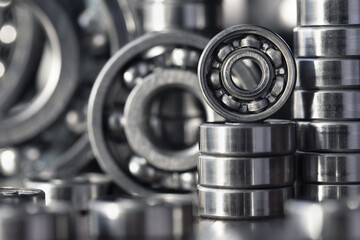 Radial ball bearings close-up in silver color for mechanical engineering, machine tools and equipment. Round steel bearings of various sizes with balls at the base with copy space.
