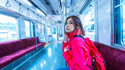 curious girl wait for next stop and ready to leave the box car with the empty Japanese train background  - 725232861