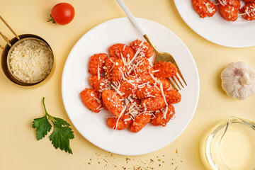 Plates of tasty gnocchi with cheese on yellow background