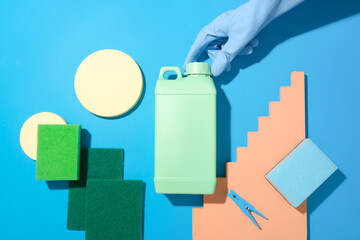 A hand wearing a rubber glove is unscrewing the lid of a jar of cleaning fluid, surrounded by...