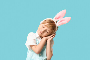 Dreaming little boy in bunny ears on blue background