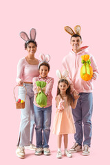 Fototapeta premium Happy family in bunny ears with Easter eggs on pink background