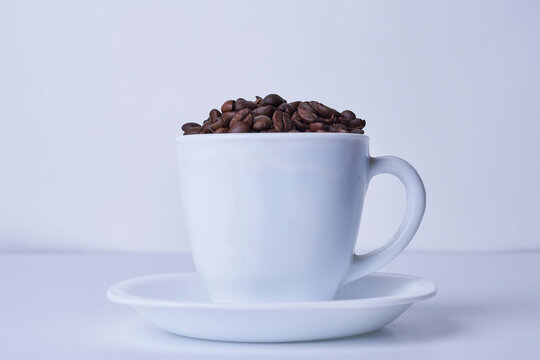 A cup filled with raw coffee beans