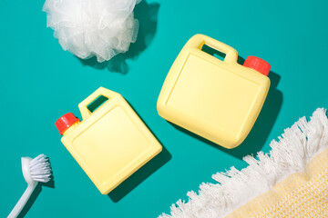 Two unlabeled yellow bottles of detergent, a toilet brush and a bath sponge stand out against the...