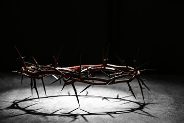 Crown of thorns with light on black grunge background