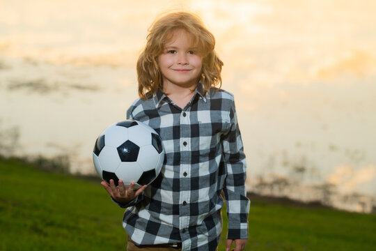 Child boy football or soccer player in action on soccer stadium kicking soccer ball for goal. Concept of sport, competition. Kid kick soccer ball. Kid kicking football ball. Sport for kids.
