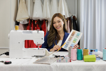 Portrait Asian cool woman designer show cloth in sewing room
