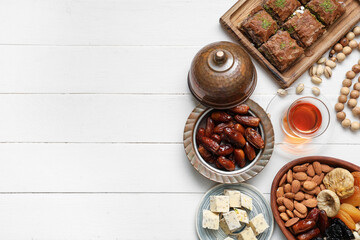 Composition with traditional Eastern sweets and tea for Ramadan on light wooden background
