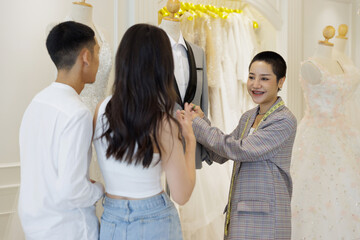 Asian couple select wedding dress in wedding studio