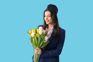 Beautiful stewardess with tulips on blue background. Easter celebration