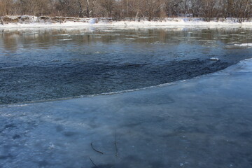 a river in winter where the ice is all covered in snow
