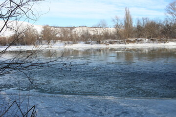 a river in winter where the ice is all covered in snow