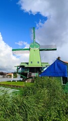 Zaanse Schans is a neighborhood in the Dutch town of Zaandam, near Amsterdam. Historic windmills and distinctive green wooden houses were relocated here to recreate the look of an 18th/19th-century vi