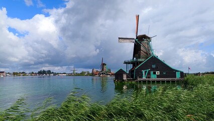 Zaanse Schans is a neighborhood in the Dutch town of Zaandam, near Amsterdam. Historic windmills and distinctive green wooden houses were relocated here to recreate the look of an 18th/19th-century vi