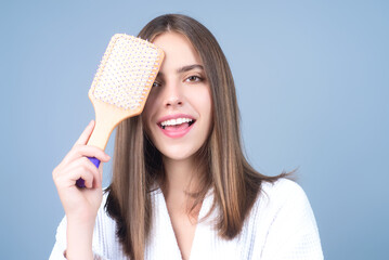 Young woman taking care with hair comb of her hair. Haircare. Pretty girl brushing hairs with comb. Beauty, hair loss products, shampoo and hair care concept. - obrazy, fototapety, plakaty