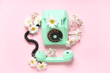 Retro telephone and beautiful gypsophila and gerbera flowers on pink background. International...