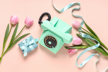 Retro telephone with gift box and beautiful tulips on pink background. International Women's Day