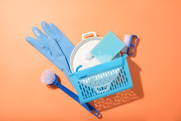 Blue cleansing product and a white ceramic plate in a plastic basket on a red background. Clean the...
