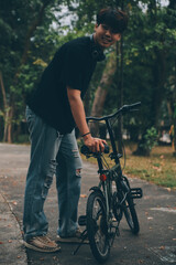 Obraz premium Young handsome bearded man taking a break while travelling the city with his bicycle using his digital tablet looking away thoughtfully